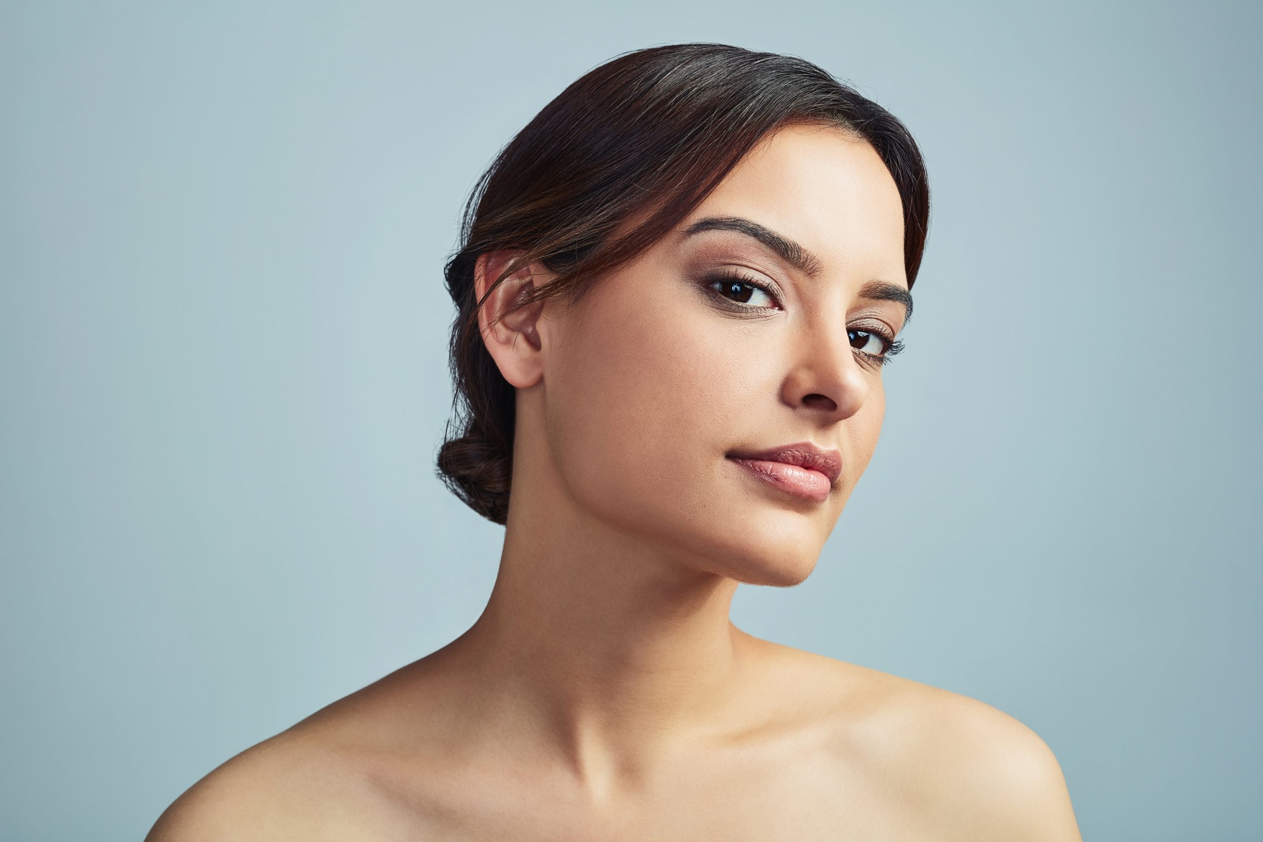 Portrait of a brunette woman with smooth, healthy-looking skin and minimal makeup, highlighting natural beauty and an even complexion.