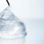 Close-up of a translucent hyaluronic acid gel droplet, representing dermal fillers used to restore facial volume, smooth wrinkles, and enhance facial contours.