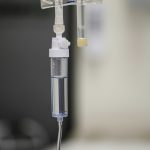 Close-up of an intravenous (IV) drip chamber containing clear fluid, representing IV hydration and wellness therapy at Vital Glow in Columbia, SC.